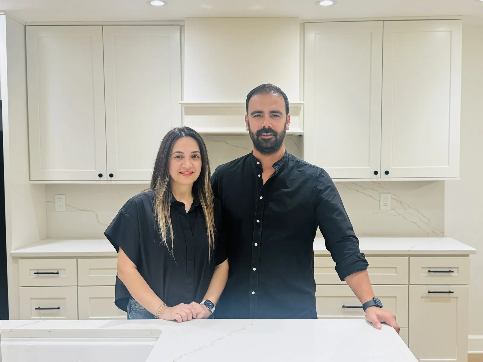 The family behind Center Cabinet, standing in a finished kitchen built by their own crew