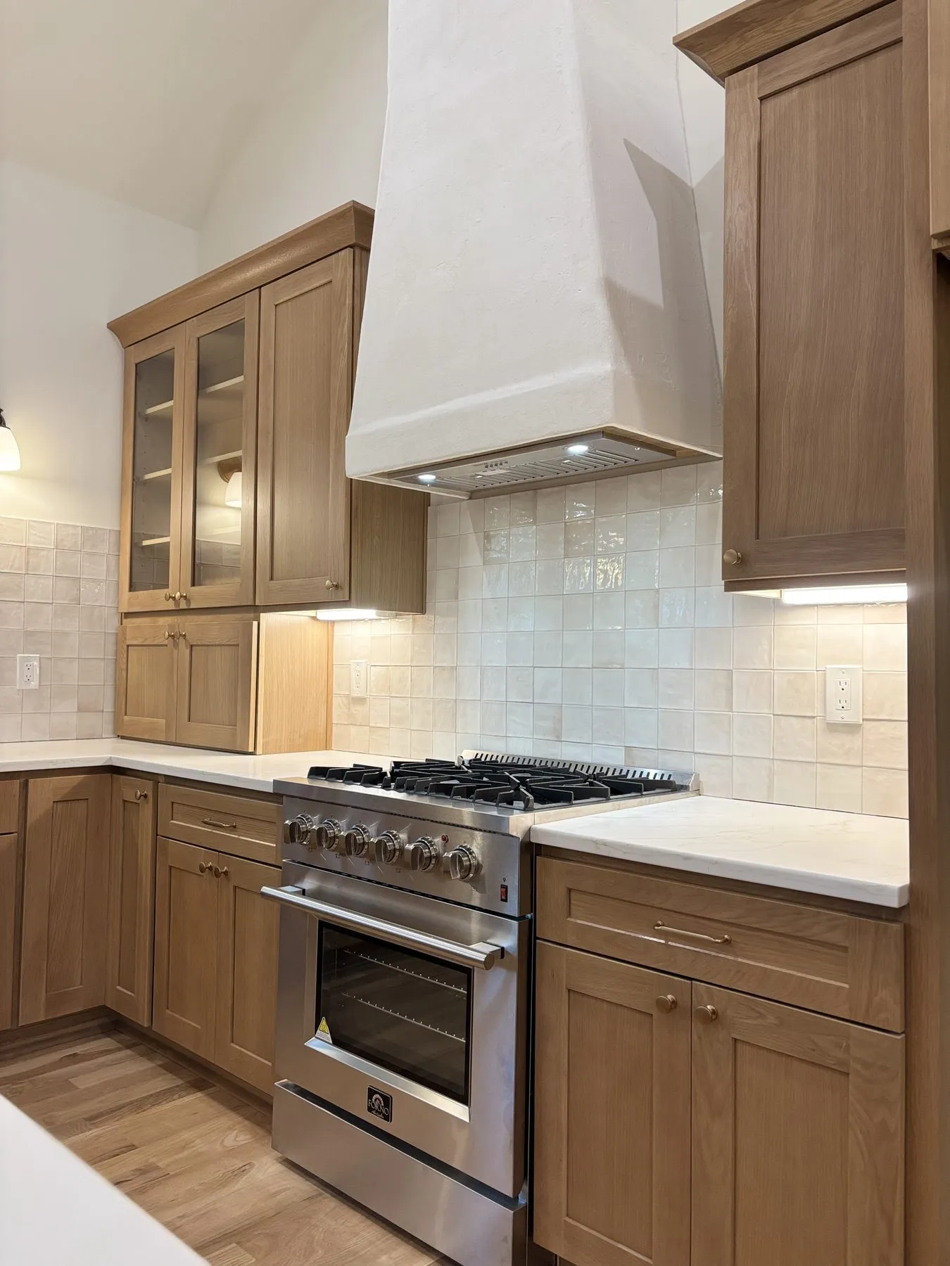 White oak kitchen with a plaster hood, built and installed by our crew